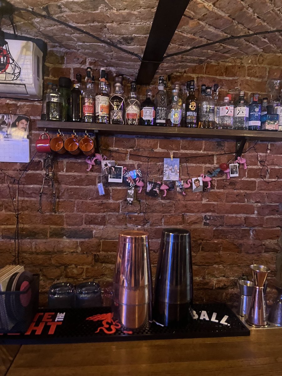 Półki z butelkami alkoholu na tle ceglanej ściany za barem